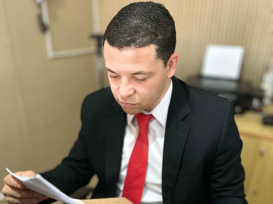 Ronalt Almeida analisando documentos no escritório